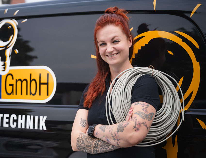 elektrikerin-mit-kabel Elektrikerin mit Kabel รผber der Schulter