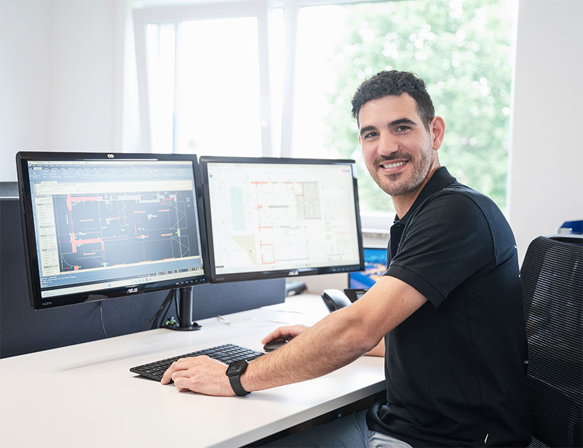rapp-elektroplanung Geschรคftsfรผhrer sitzt am PC Bildschirm mit einem Grundriss und plant die Elektronik eines Hauses